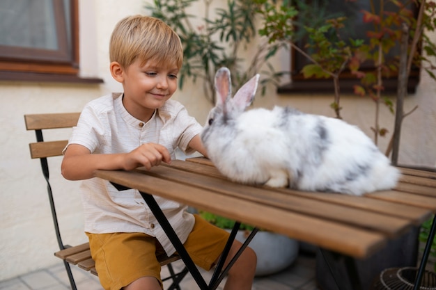 Foto gratuita retrato de niño con su mascota conejo