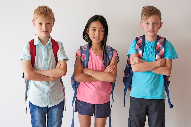 Retrato de niños de primaria contra la pared blanca