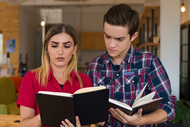 Retrato de las notas serias de la lectura del muchacho y de la muchacha en cuadernos