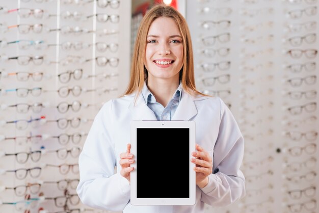 Retrato de optometrista amable enseñando plantilla de tableta