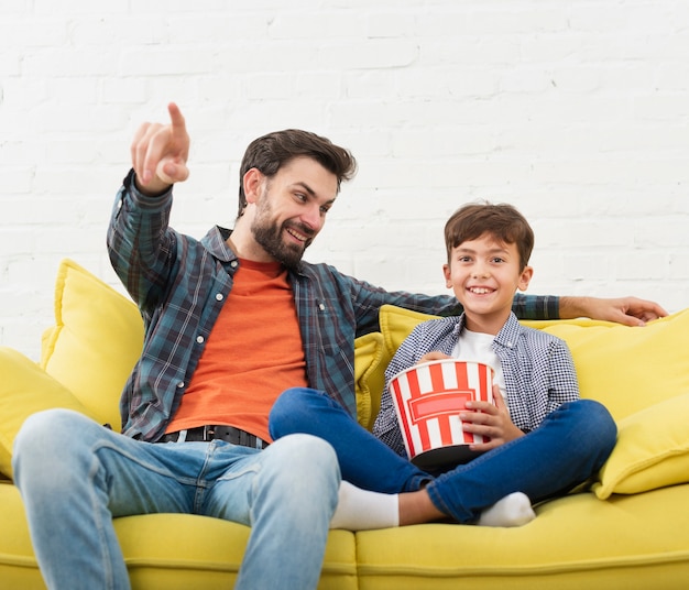 Foto gratuita retrato de padre e hijo sentados en el sofá