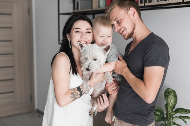 Foto gratuita retrato de unos padres sonrientes llevando a su hijo y su perro