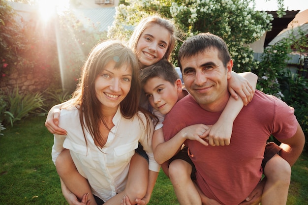 Retrato de padres sonrientes con sus hijos en el parque