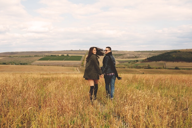 Retrato del paisaje de la joven pareja elegante hermosa sensual y divirtiéndose al aire libre