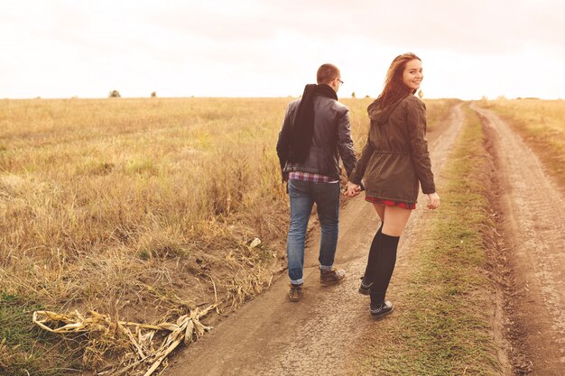 Retrato del paisaje de la joven pareja elegante hermosa sensual y divirtiéndose al aire libre