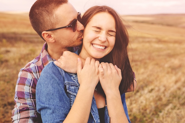 Retrato del paisaje de la joven pareja elegante hermosa sensual y divirtiéndose al aire libre