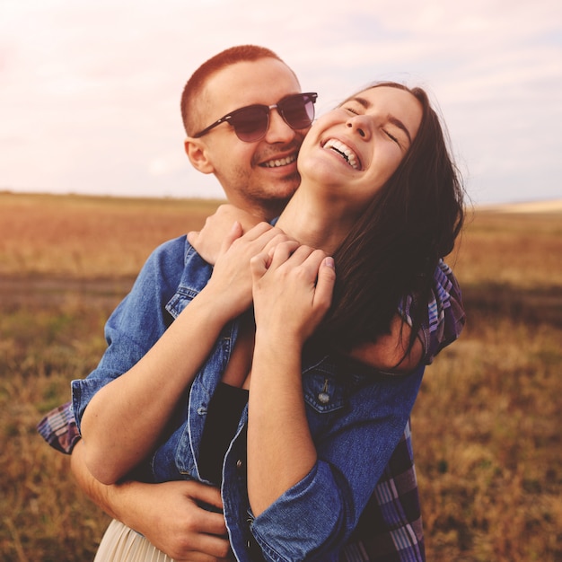 Retrato del paisaje de la joven pareja elegante hermosa sensual y divirtiéndose al aire libre