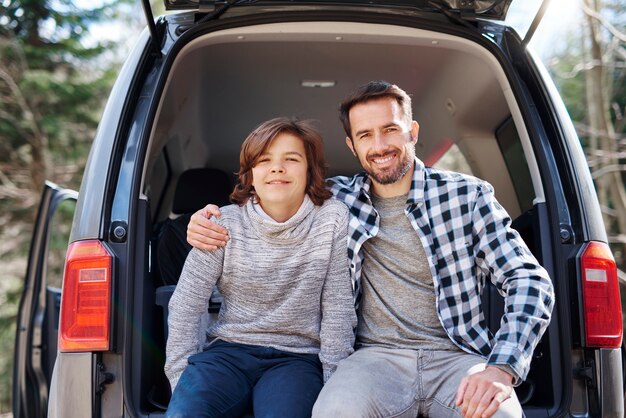 Retrato de papá alegre y su hijo adolescente abrazando