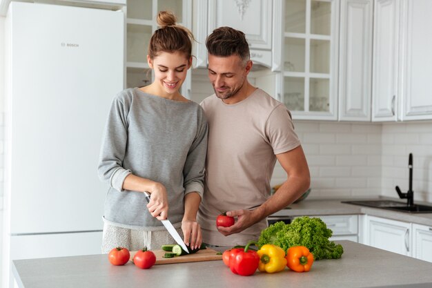 Retrato de una pareja amorosa sonriente cocinar ensalada