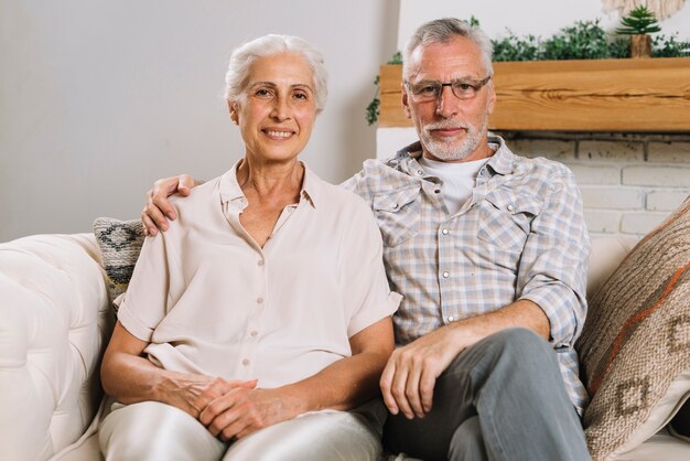 Retrato de una pareja de ancianos que se sienta en el sofá