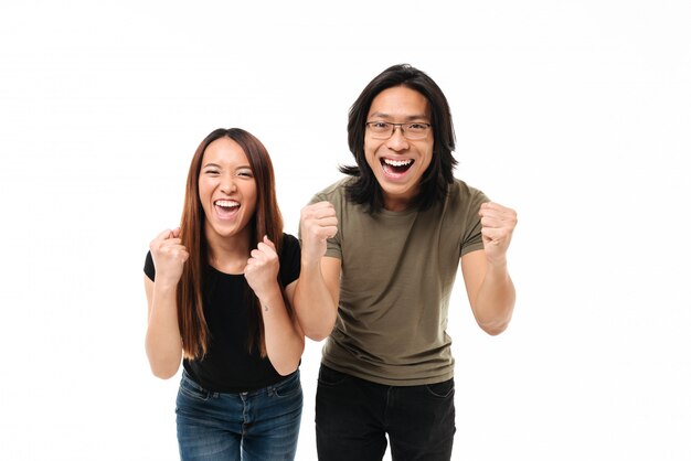 Retrato de una pareja asiática satisfecha celebrando el éxito