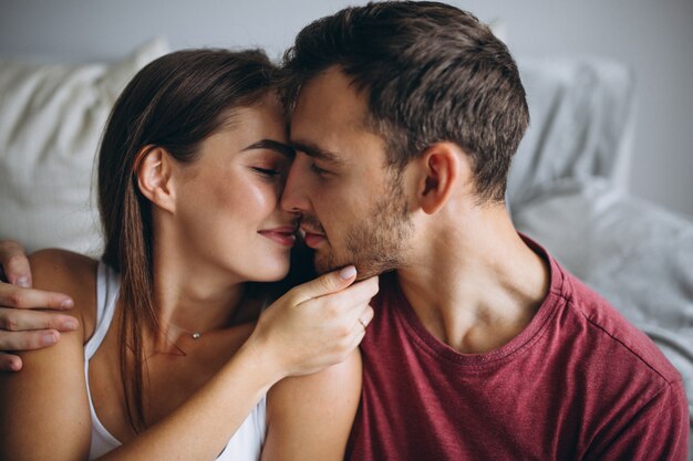 Retrato de pareja en casa juntos sentados en el piso junto al sofá