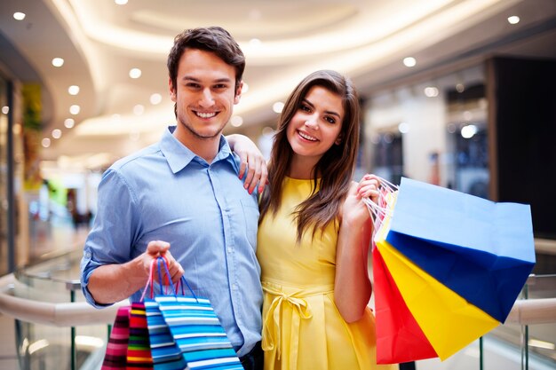 Retrato de pareja feliz con bolsas de la compra.