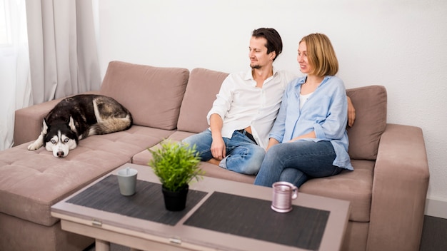 Retrato de pareja feliz en casa con perro