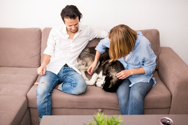 Retrato de pareja feliz en casa con perro