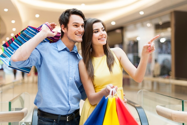 Retrato de pareja feliz en el centro comercial