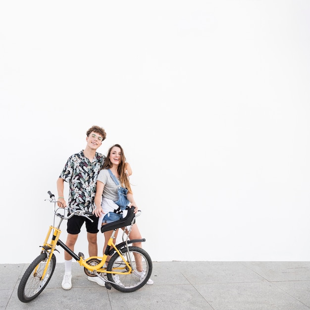 Retrato de una pareja feliz con pie de bicicleta en la acera