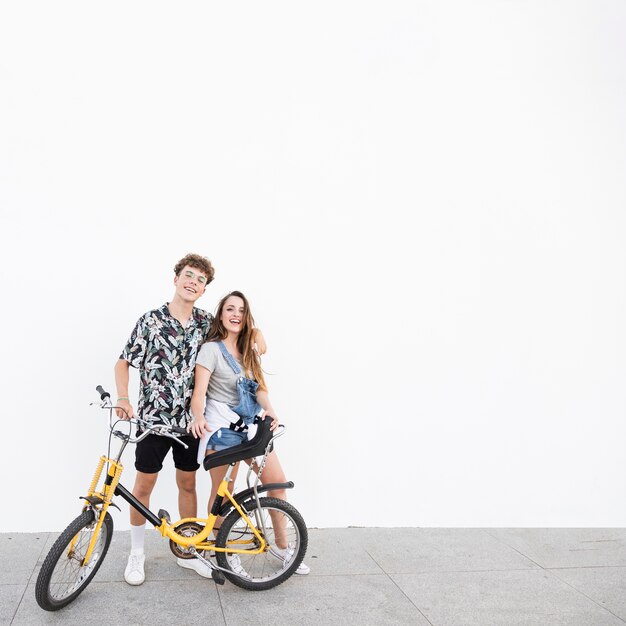 Retrato de una pareja feliz con pie de bicicleta en la acera