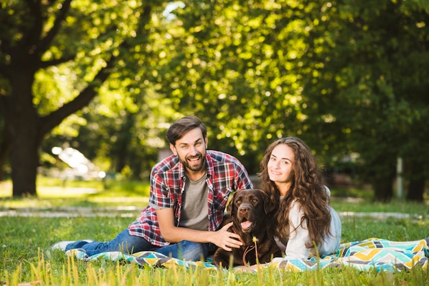 Retrato de una pareja feliz con su perro en el parque