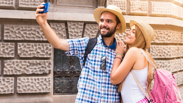 Retrato de pareja feliz tomando selfie en smartphone