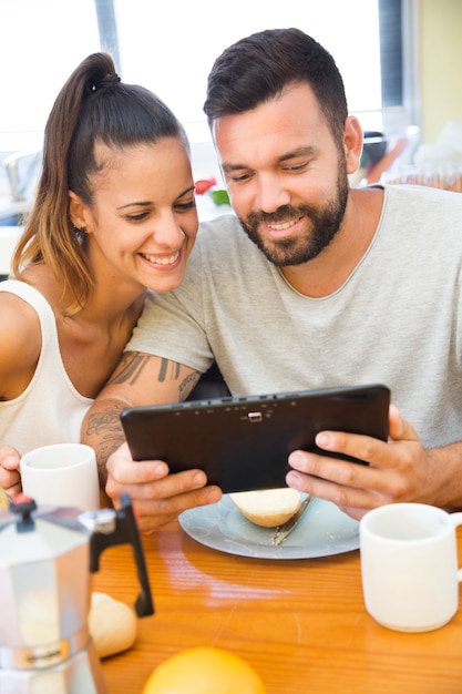 Foto gratuita retrato de una pareja feliz usando tableta digital