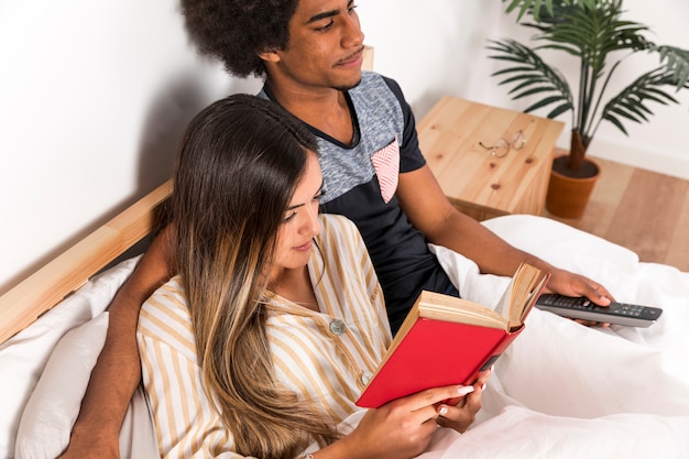 Retrato de pareja interracial leyendo juntos