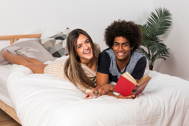 Retrato de pareja interracial leyendo juntos