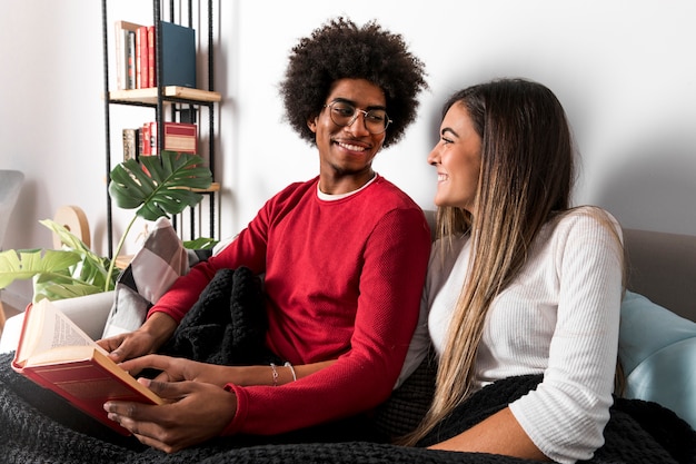 Retrato de pareja interracial leyendo juntos