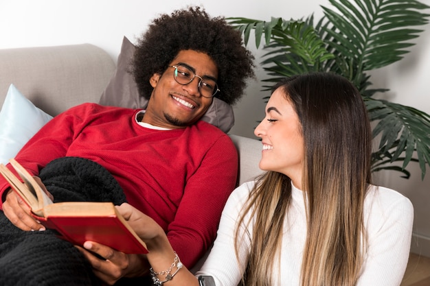 Retrato de pareja interracial leyendo juntos