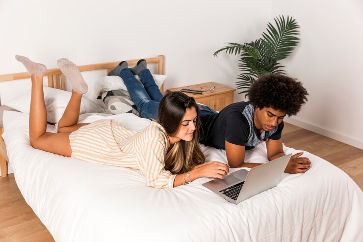 Foto gratuito retrato de pareja interracial usando portátil juntos