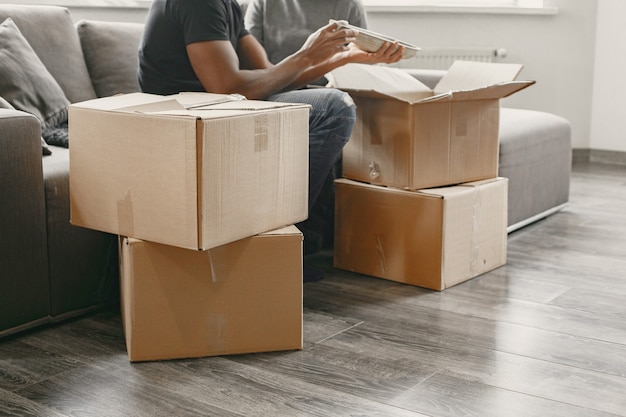 Retrato de pareja joven con cajas de cartón en casa nueva, concepto de casa móvil.