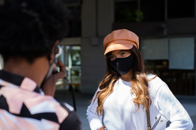 Retrato de pareja joven turista con máscara protectora y con cámara mientras toma fotografías en la ciudad. Concepto de turismo. Nuevo concepto de estilo de vida normal.