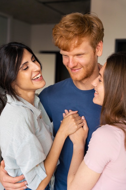 Foto gratuita retrato de pareja poliamorosa en casa mostrando cariño