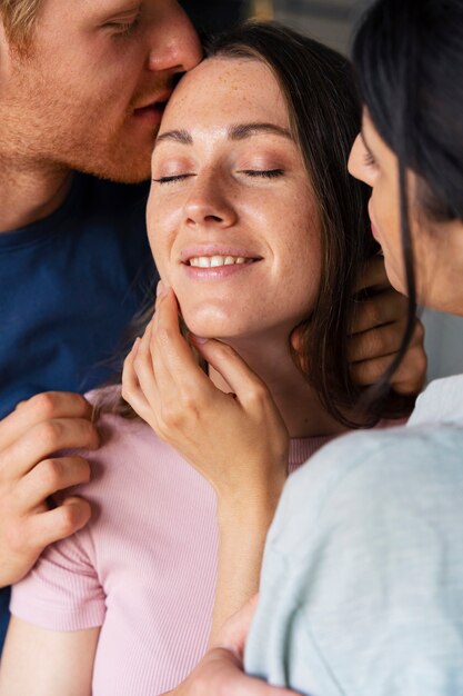 Retrato de pareja poliamorosa en casa mostrando cariño