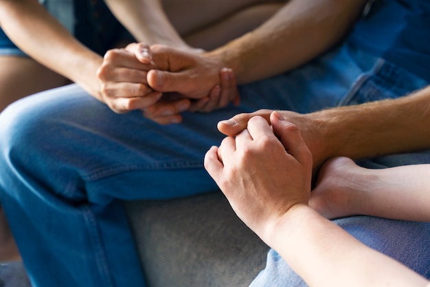 Foto gratuita retrato de pareja poliamorosa en casa tomados de la mano