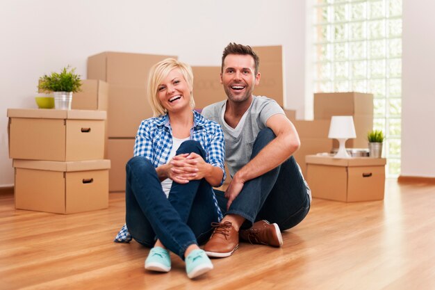 Retrato de pareja riendo en casa nueva