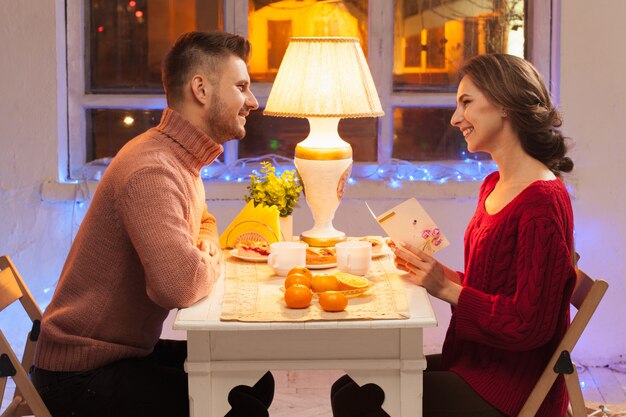 Retrato de pareja romántica en la cena de San Valentín con regalo