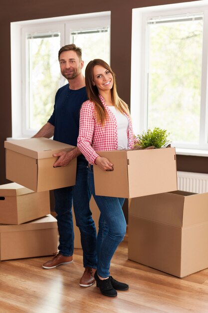 Retrato de pareja sonriente durante la mudanza a casa