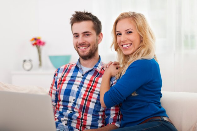 Retrato de pareja sonriente con portátil contemporáneo