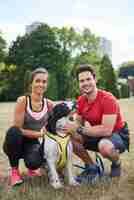 Foto gratuita retrato de pareja sonriente y su perro después del entrenamiento