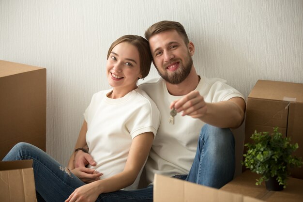 Retrato de pareja sosteniendo llaves emocionados para moverse juntos