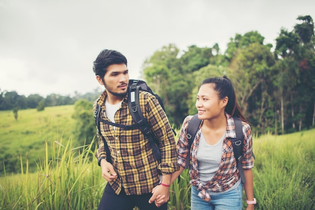 Retrato de los pares jovenes felices que caminan divirtiéndose en su viaje que camina. Concepto de pareja