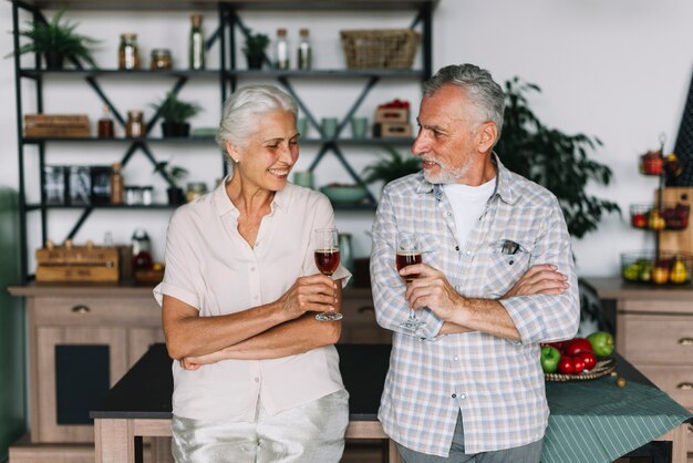 Retrato de los pares mayores sonrientes que sostienen las copas de vino disponibles