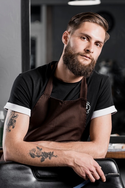 Foto gratuita retrato de un peluquero masculino con maquinilla de afeitar