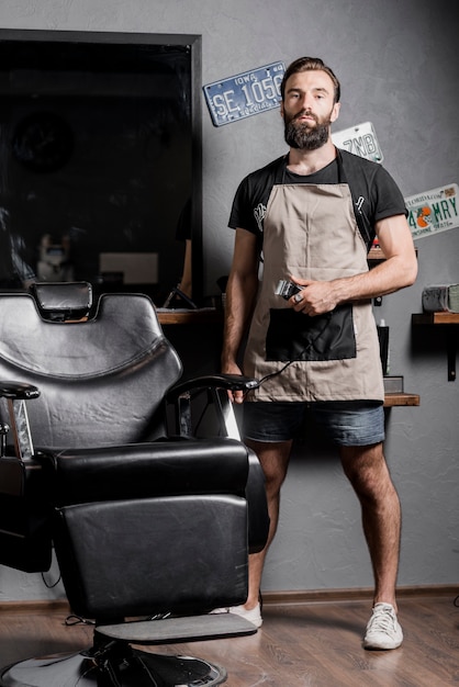 Retrato de un peluquero masculino con trimmer eléctrico