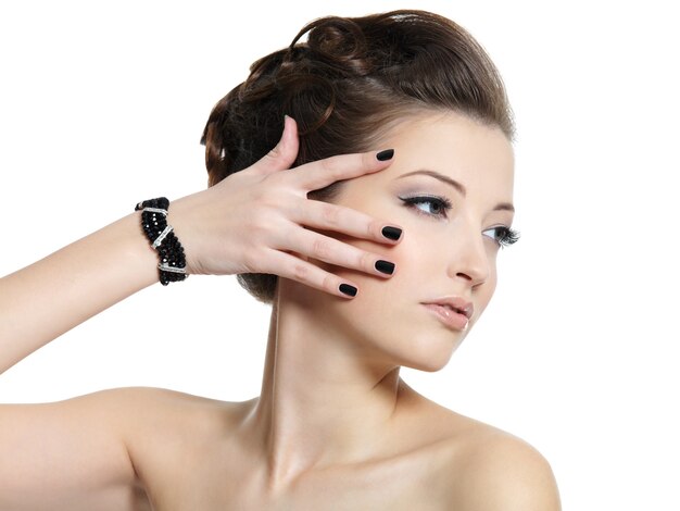 Retrato de perfil de la hermosa chica glamour con uñas negras aisladas en blanco