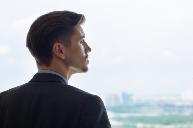 Retrato de perfil de hombre serio mirando por la ventana