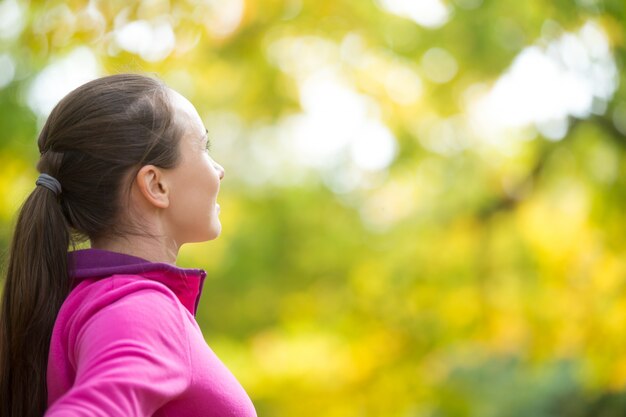 Retrato del perfil de una mujer atractiva del deporte al aire libre