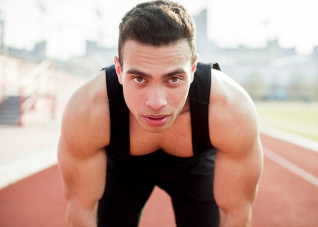 Retrato de persona de deporte muscular seguro mirando a cámara