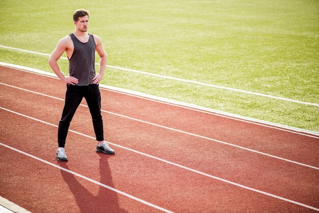 Retrato de persona deportiva confía en pie en pista